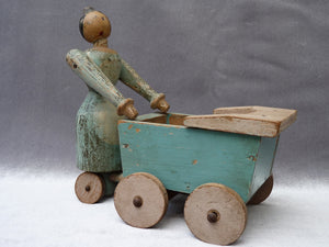 Ancienne poupée naïve avec landau en bois peint